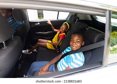 Portrait of smiling african american brother and sister with seat belts traveling in car. unaltered, family, childhood, safety, weekend and travel concept. - Powered by Shutterstock