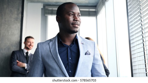 Portrait Of Smiling African American Business Man With Executives Working In Background 