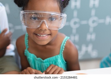 Portrait of smiling african american elementary schoolgirl wearing protective eyewear in laboratory. unaltered, education, learning, laboratory, stem, experiment, protection and school concept. - Powered by Shutterstock