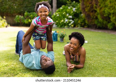 Portrait Of Smiling African American Family Lying On Grass At Backyard Garden. Family, Love And Togetherness Concept, Unaltered.