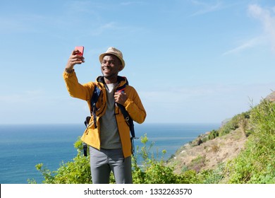 Portrait Of Smiling African American Hiker Taking Selfie In Nature