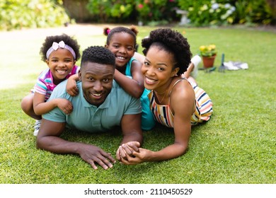 Portrait of smiling african american lying together on lawn at backyard garden. family, love and togetherness concept, unaltered. - Powered by Shutterstock