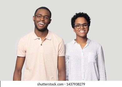 Portrait of smiling african American man and woman stand isolated on grey studio background look at camera, happy biracial ethnic couple in glasses laugh posing together for picture - Powered by Shutterstock