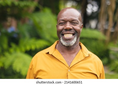 Portrait Of Smiling African American Senior Man Standing In Backyard On Weekend. Unaltered, Lifestyle, Leisure And Retirement.