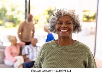Portrait of smiling african american senior woman standing with multiracial friends in background. Nursing home, unaltered, friendship, togetherness, support, assisted living and retirement concept. - Shutterstock ID 2180795511