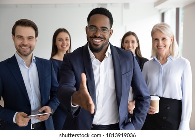 Portrait of smiling African American team leader stretch hand greeting job candidate or applicant in office. Happy multiracial businesspeople meet welcome newcomer at workplace. Employment concept. - Shutterstock ID 1813919036
