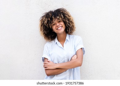 Portrait smiling african American teen girl with arms crossed by white background 