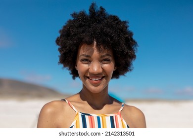 Portrait of smiling african american woman with black afro hair at beach on sunny day. unaltered, lifestyle, hairstyle and summer holiday concept. - Powered by Shutterstock