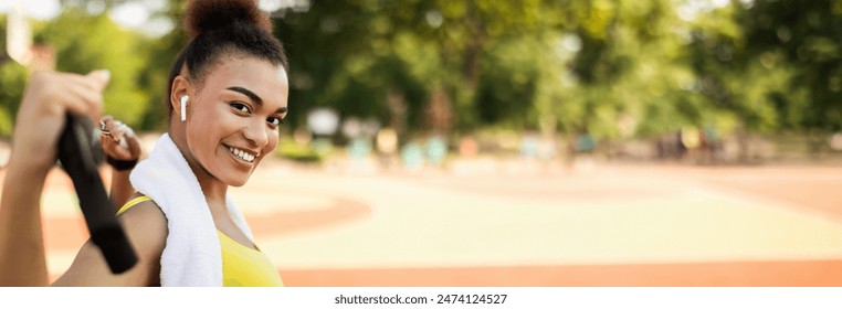 Portrait of smiling African American woman doing workout training using equipment for body stretching exercise outside. Attractive lady enjoying outdoor activity, panorama with copy space - Powered by Shutterstock