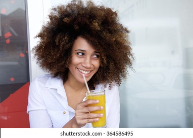 Portrait of a smiling african american woman drinking juice