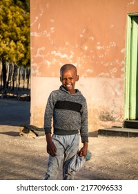 Portrait Of A Smiling African Boy In The Village At Sunset