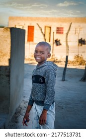 Portrait Of A Smiling African Boy In The Village At Sunset