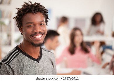 Portrait Of A Smiling African College Student Standing In Front Of His Peers.