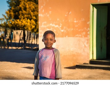 Portrait Of A Smiling African Girl With Pink Blouse At Sunset In A Village In Africa