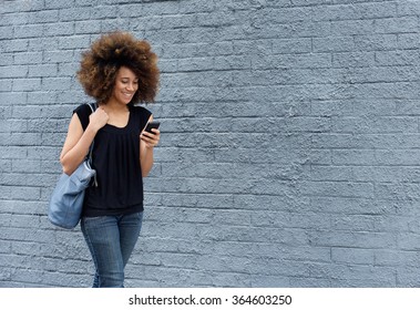 Portrait Of Smiling African Woman Walking With Cell Phone