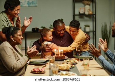 Portrait of smiling African-American man embracing children while celebrating Birthday with big happy family - Powered by Shutterstock