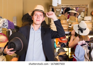 portrait of smiling american young guy try on  panama at headwear store - Powered by Shutterstock