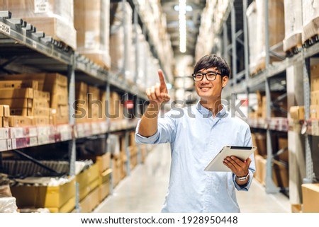 Portrait of smiling asian engineer foreman in helmets man order details checking goods and supplies on shelves with goods background in warehouse.logistic and business export