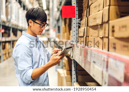 Portrait of smiling asian engineer foreman in helmets man order details checking goods and supplies on shelves with goods background in warehouse.logistic and business export