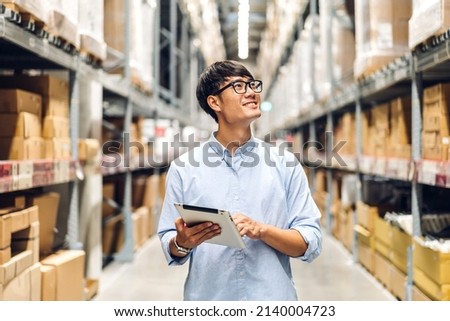 Portrait of smiling asian engineer foreman in helmets man order details checking goods and supplies on shelves with goods background in warehouse.logistic and business export