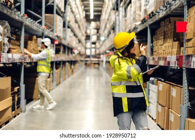 Portrait of smiling asian engineer in helmets woman order details on tablet computer for checking goods and supplies on shelves with goods background in warehouse.logistic and business export