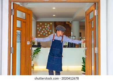 Portrait Of Smiling Asian Man Coffee Shop Manager Open Shop Door And Standing With Crossing Arms. Male Cafe Owner Waiting For Customer With Happiness. Small Business Restaurant Entrepreneur Concept