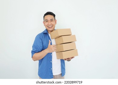 Portrait smiling Asian man holding post boxes standing over isolated background with copy space. - Powered by Shutterstock