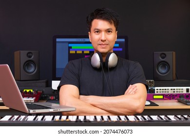 Portrait Of Smiling Asian Professional Music Producer, Composer, Sound Engineer, Arranger In Recording Studio