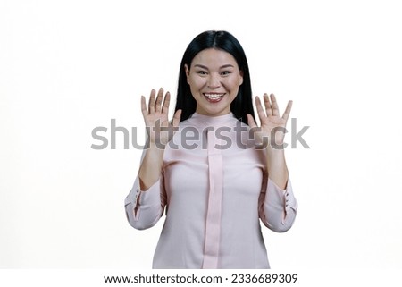 Portrait of smiling asian woman with her hands up. Isolated on white background.