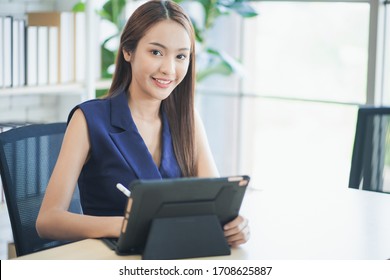 Portrait Of Smiling Asian Woman Working On Laptop At Office. 