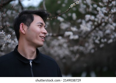 Portrait Of Smiling Asian Young Man Profile Face With Blur Plum Blossom Flower Tree