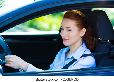 Portrait Smiling, Attractive Brunette Woman, Buckled Up, Driving, Testing Her New Black Car, Automobile, Purchased At Dealership, Isolated Street, City Traffic Background. Safe Driving Habits Concept