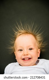 Portrait Of Smiling Baby With Standing Hair From Static Electricity