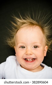 Portrait Of Smiling Baby With Standing Hair From Static Electricity