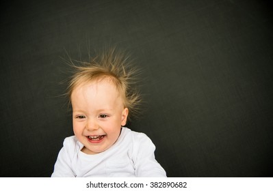 Portrait Of Smiling Baby With Standing Hair From Static Electricity