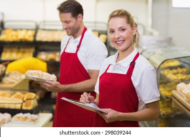 Portrait of a smiling baker with her colleague in bakery - Powered by Shutterstock