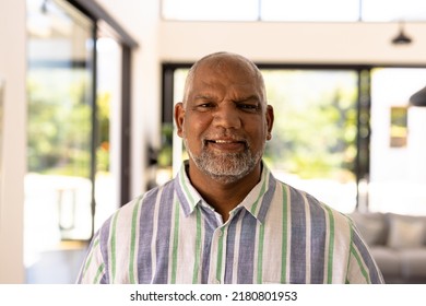 Portrait of smiling bald biracial senior man against windows in nursing home. Happy, confident, unaltered, support, assisted living and retirement concept. - Powered by Shutterstock