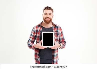 Portrait of a smiling bearded man showing blank tablet computer screen over white background
