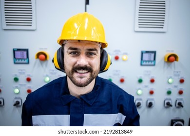 Portrait Of Smiling Bearded Worker Standing Inside Factory Building.