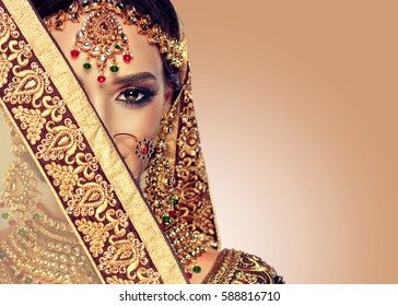 Portrait  smiling of beautiful indian girl. Young indian woman model with golden kundan jewelry set . Traditional Indian costume lehenga choli . 