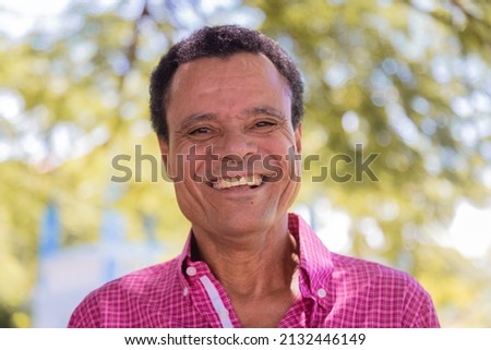 Portrait of smiling beautiful older male farmer. Elderly man at farm in summer day. Gardening activity. Brazilian elderly man.