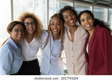 Portrait of smiling beautiful successful young african american business women in formal wear posing in modern workplace. Happy millennial diverse biracial female employees looking at camera. - Powered by Shutterstock