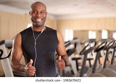 Portrait of smiling black man in fitness club. He has thumbs up in positive attitude. Concept of sport and healthy life.