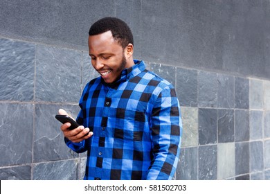 Portrait Of Smiling Black Man Looking At Mobile Phone 