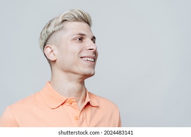 Portrait of a smiling blonde man standing in front of a gray background close up with copy space - Powered by Shutterstock