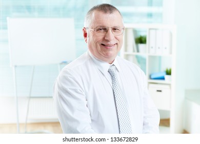Portrait of smiling boss looking at camera in office