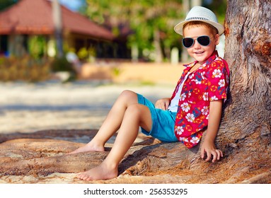 Portrait Of Smiling Boy Sitting Under The Tree