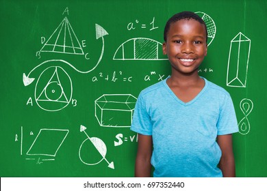 Portrait of smiling boy standing against blackboard with copy space on wooden board