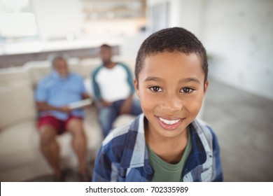 Portrait of smiling boy standing in living room at home