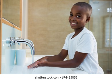 Portrait of smiling boy washing hands in sink at bathroom, Coronavirus hand washing for clean hands hygiene Covid19 spread prevention